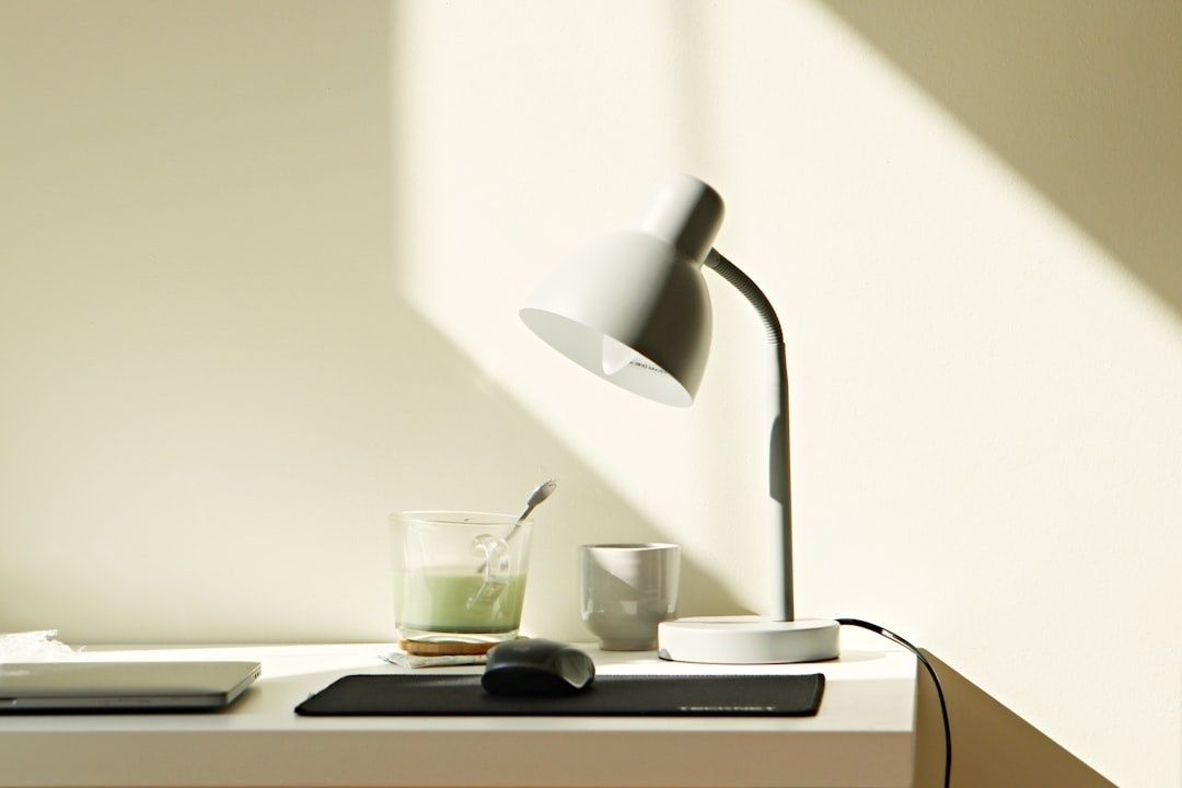 Rustige, minimalistische werkplek met lamp, muis en glazen op een bureau