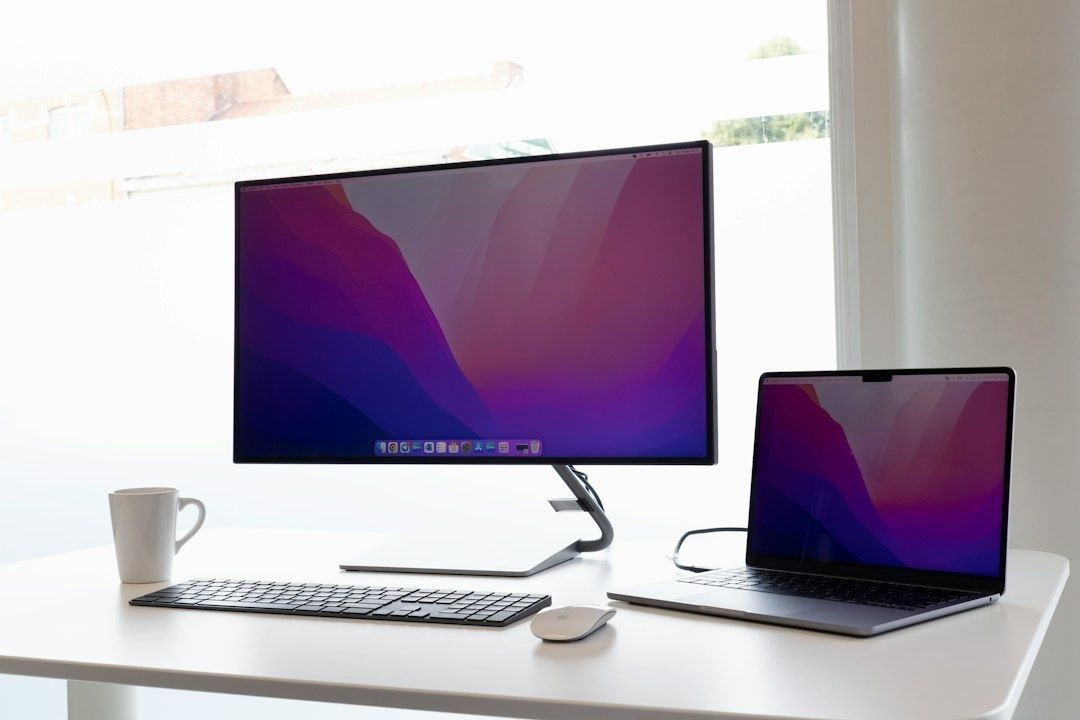 Minimalistische werkplek met laptop, monitor, toetsenbord en muis